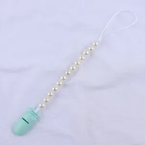 Detail of baby pacifier clip with cream faux pearls and mint green plastic fastener