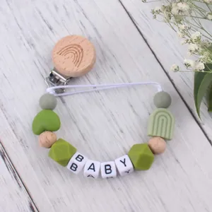 Nahaufnahme von Silikonperlen und Holzclip der Regenbogen-Schnullerkette mit BABY-Text