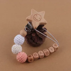 Détail de l'attache-tétine en bois avec perles au crochet, pomme de pin et perles BABY