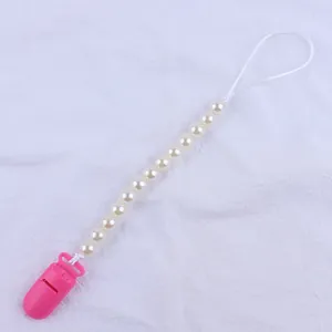 Close-up of pink plastic clip and white faux pearl beads on a baby pacifier chain