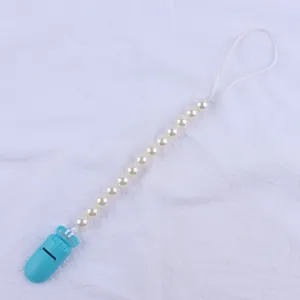 Detail of sky blue plastic clip and white pearl beads on baby pacifier leash
