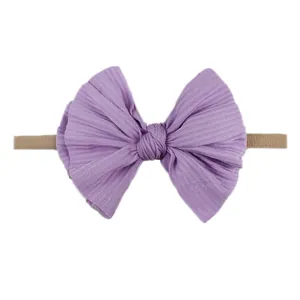 Bandeau bébé avec nœud en tricot lavande doux et ruban en nylon élastique sur fond blanc