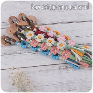 Detail der handgefertigten Schnullerkette aus Baumwollseil mit bunten Blumen und Buchenholz