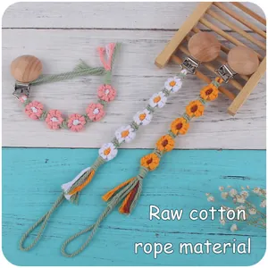 Détail de l'attache-tétine en corde de coton faite main avec fleurs tissées et clip en hêtre