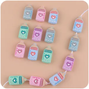 Detalle de cuentas de silicona con forma de biberón y patrón de corazón para cadenas de chupete