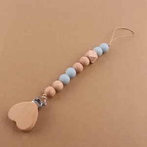 Detail of wooden heart clip and light blue silicone beads on a baby pacifier chain