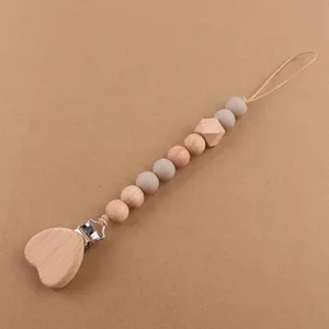 Detailed view of heart-shaped wooden pacifier clip with silicone beads for baby teething