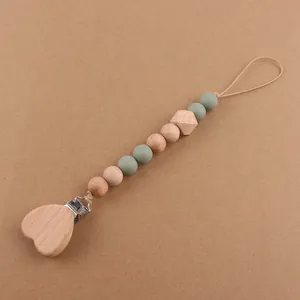 Detail of baby pacifier clip with beech wood heart clamp and green silicone beads