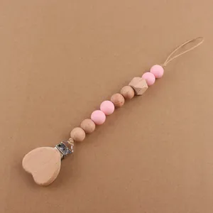 Detail of baby pacifier clip with heart wooden clasp and pink silicone beads