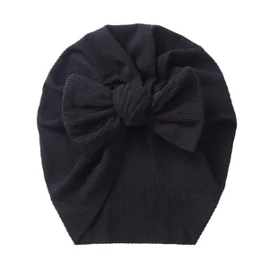 Detailed close-up of ribbed fabric texture and large bow on baby turban hat