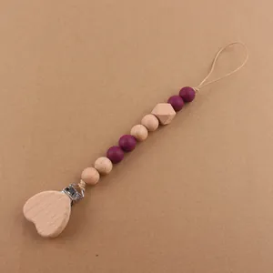 Detailed view of handmade baby pacifier clip with purple silicone and heart beechwood beads