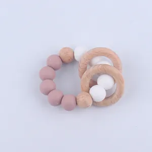Macro detail of silicone beads and beech wood rings on infant teething bracelet