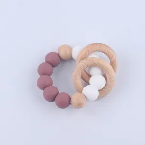 Macro detail of silicone and beech wood teething rings for infants in muted tones