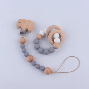 Detalle de sujetachupete de elefante de madera y mordedor de silicona en fondo blanco