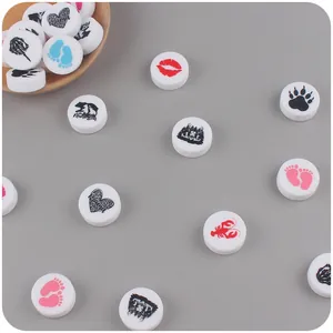 Detailansicht runder Silikonperlen mit Mama Bär und Baby-Fußabdruck Motiven für DIY-Ketten