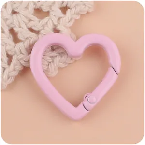 Detailed macro view of a pink heart-shaped spring ring clasp for DIY jewelry making