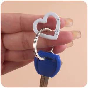 Close-up of a white heart-shaped carabiner spring hook with silver metal key ring