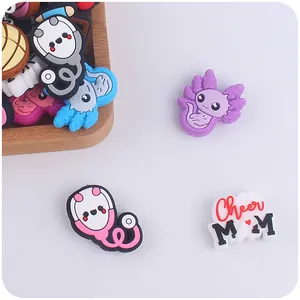 Macro detail of cartoon axolotl and stethoscope PVC charms for creative DIY accessories