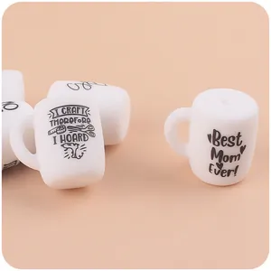 Gedetailleerd zicht op witte siliconen bekerkralen met Best Mom Ever en craft tekstprint