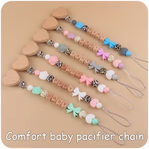Detail of pacifier clips with beech wood hearts and silicone bow beads in six colors
