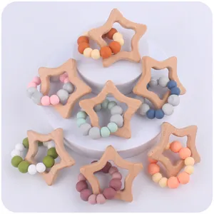 Detail of star-shaped beech wood baby teether with colorful silicone beads and smooth edges