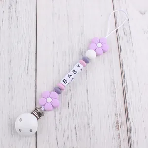 Detailed view of handmade silicone pacifier clip with flower beads and baby letter cubes