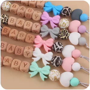 Baby pacifier clip with wood heart beads and silicone bow tie in pastel colors