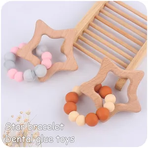 Macro detail of star-shaped beech wood teether with colorful silicone beads bracelets