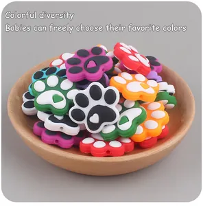 Close-up of colorful cat paw silicone beads in a wooden bowl for DIY pacifier chains