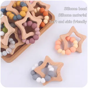 Detail of star-shaped beech wood teether with colorful silicone beads for babies