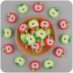 Detailed close-up of red and green apple silicone beads for DIY baby pacifier chains