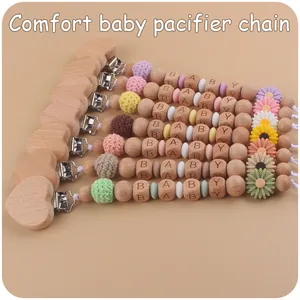 Macro detail of baby pacifier clip with beech wood heart and daisy silicone beads