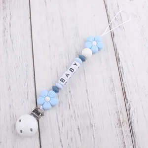 Close-up of silicone baby pacifier clip with flower beads and BABY letter squares