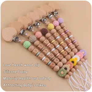 Detail of wooden beech pacifier clips with silicone daisy beads and crochet textures