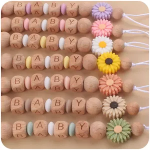 Detail of wooden baby pacifier clips with daisy silicone beads and baby letter beads