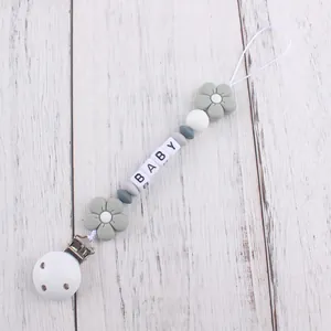 Close-up of grey and white silicone flower pacifier clip with BABY letter beads