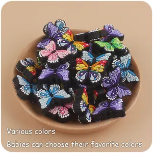 Breloques papillons colorées en silicone pour attache-sucettes sur plateau bois