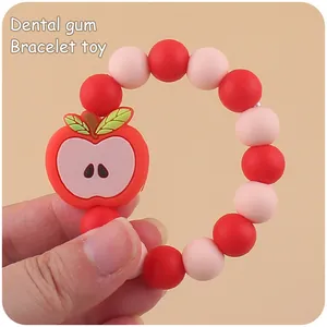 Close-up of baby dental gum bracelet with red apple pendant and colorful silicone beads