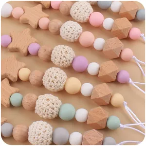 Detail of baby pacifier clip with star-shaped beech wood and colorful silicone beads