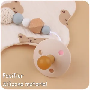 Détail de la tétine en silicone et de l'attache-tétine perlée avec motif cœur