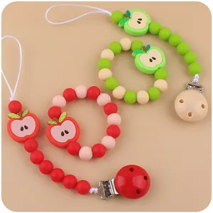 Detail of food-grade silicone baby pacifier clips and apple shaped teething rings set