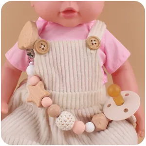 Détail de l'attache-tétine bébé avec étoiles en bois et perles en silicone rose