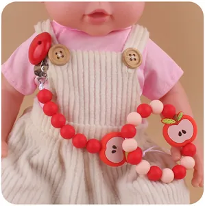 Close-up of red apple silicone pacifier clip and teething ring set for infants