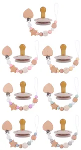 Détail d'attaches-tétines pour bébé avec perles silicone et clips en bois en forme de cœur