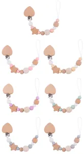 Close-up of beech wood pacifier clips with colorful beads and crochet textures