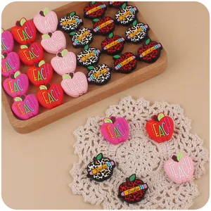 Detailed view of colorful apple-shaped silicone beads for DIY pacifier clips and crafts