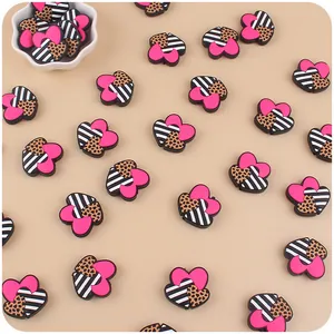 Close-up of heart-shaped silicone teethers with leopard, pink, and striped patterns