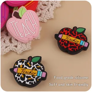 Detail of apple-shaped silicone focal beads with Teacher pencil design for DIY pacifier clips