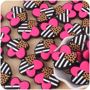 Macro shot of three stacked silicone heart beads with leopard and stripe patterns