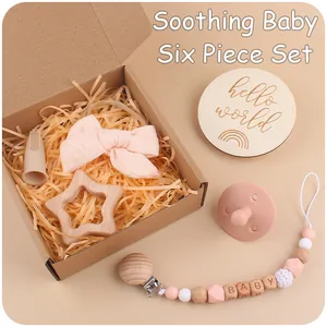 Pink baby gift set featuring wooden star teether, pacifier clip and bow headband